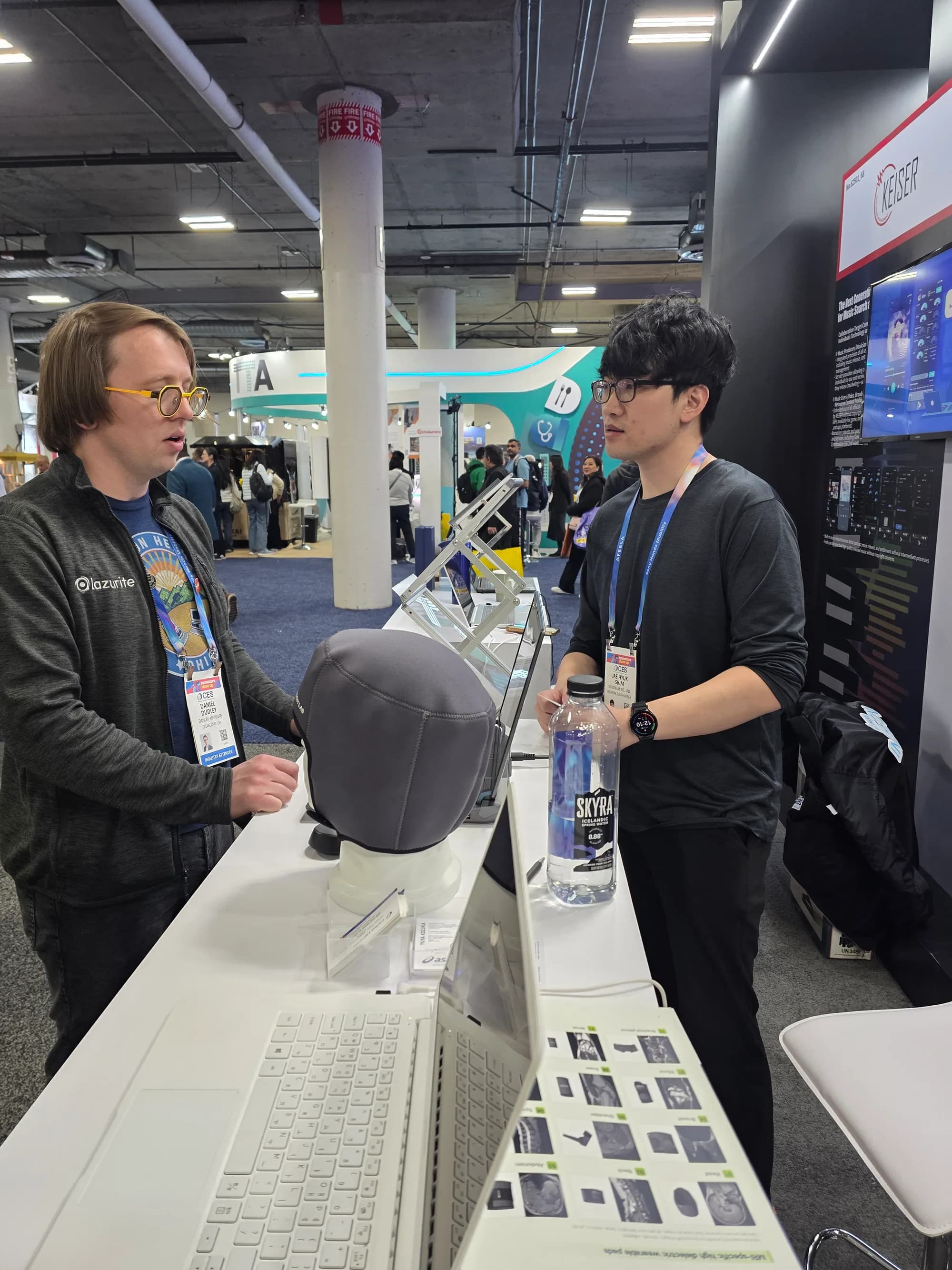 CES 2026 attendee examining a head MRI dielectric pad with an MTechLab representative