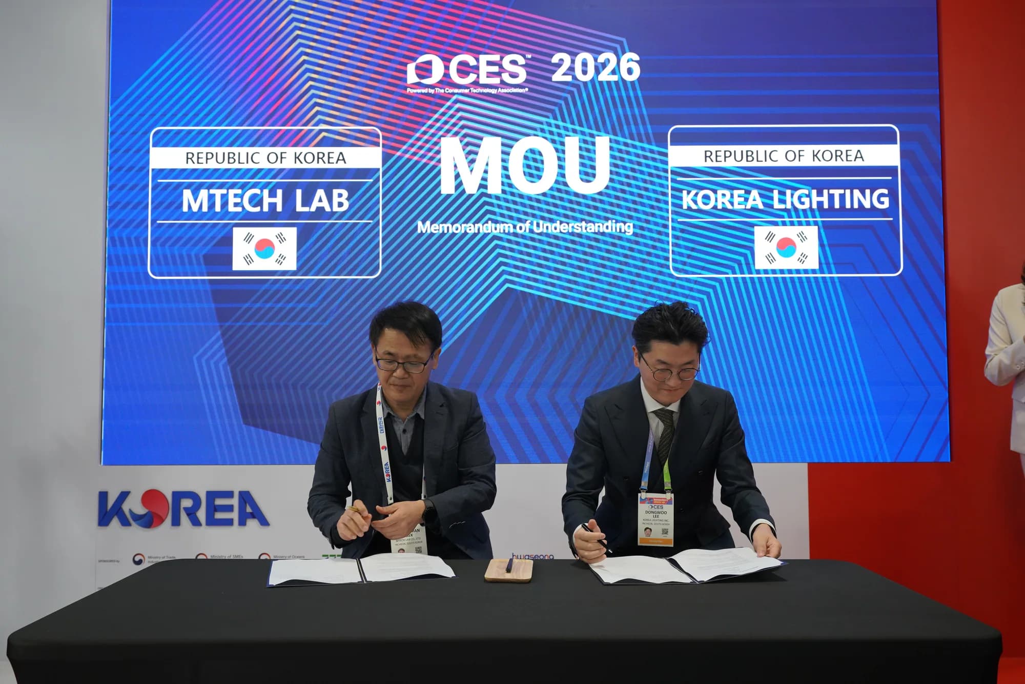 MTechLab and Korea Lighting representatives seated at the CES 2026 signing ceremony