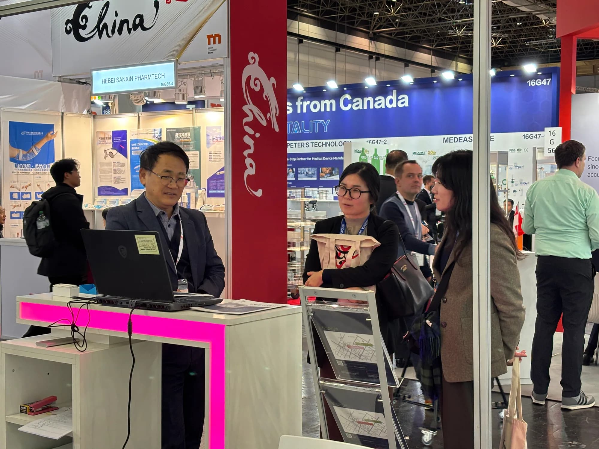 MTechLab exhibitor speaking with a MEDICA 2025 visitor at the MRI analysis workstation