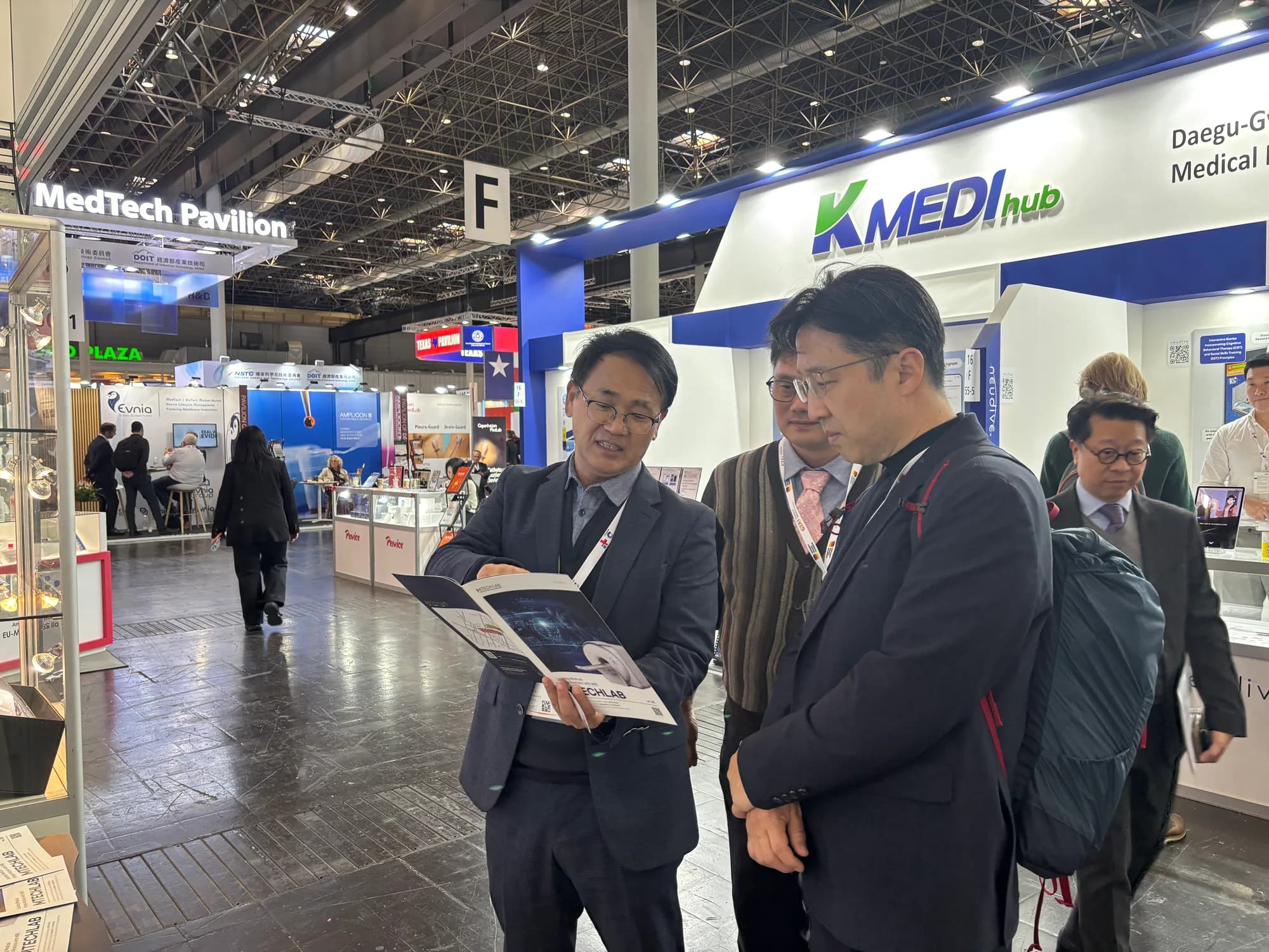 MTechLab representatives reviewing a printed MRI dielectric pad catalogue