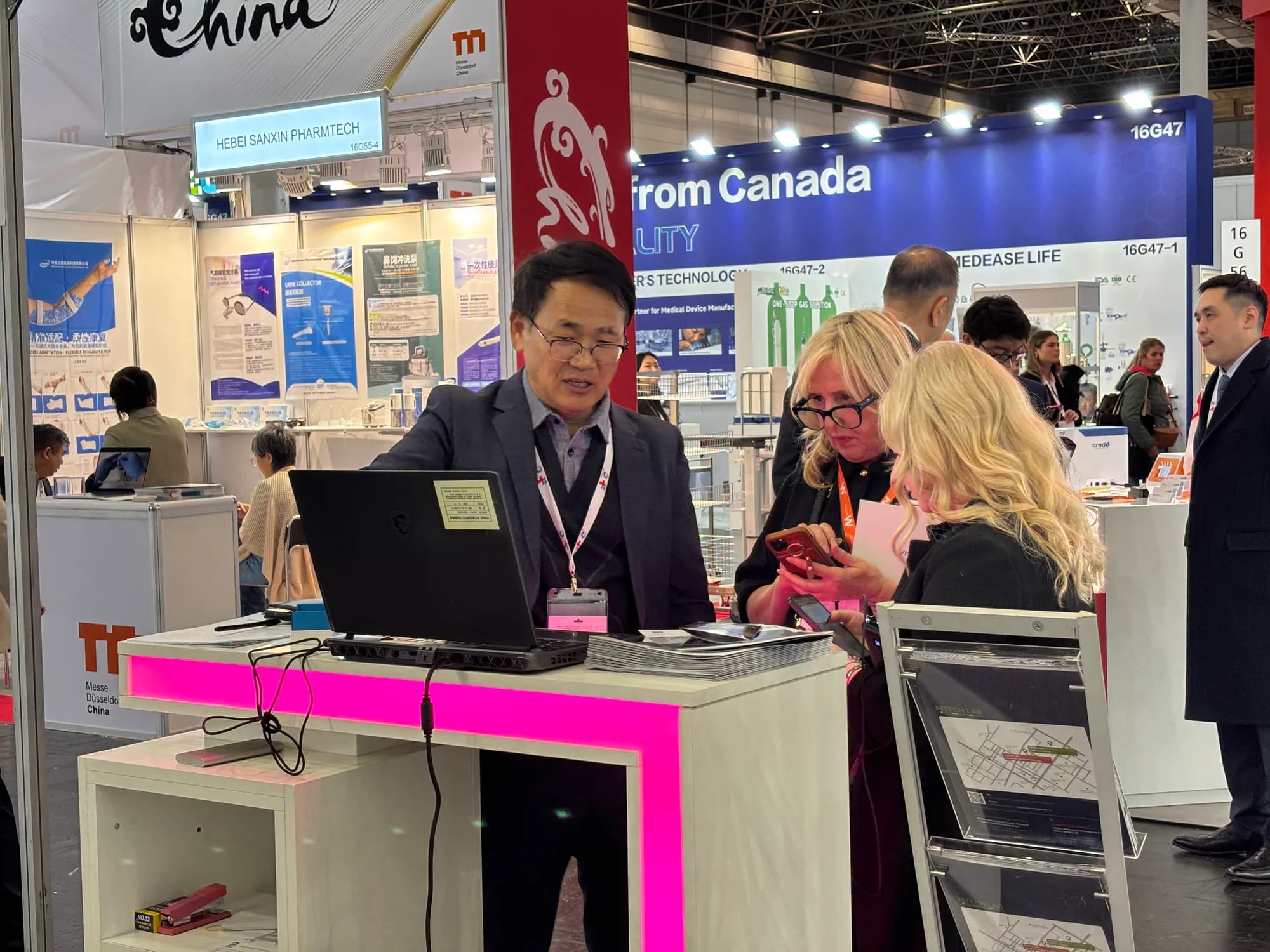 MTechLab representative discussing the MRI analysis workstation with a visitor