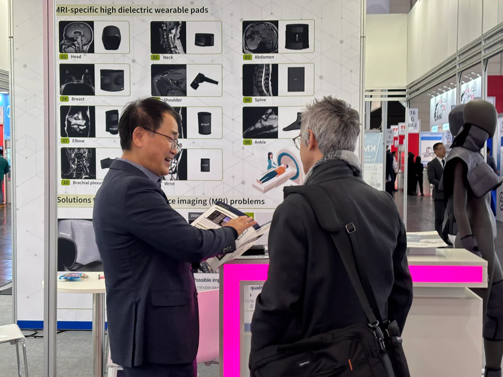 MTechLab representative explaining MRI dielectric pads to MEDICA 2025 visitors