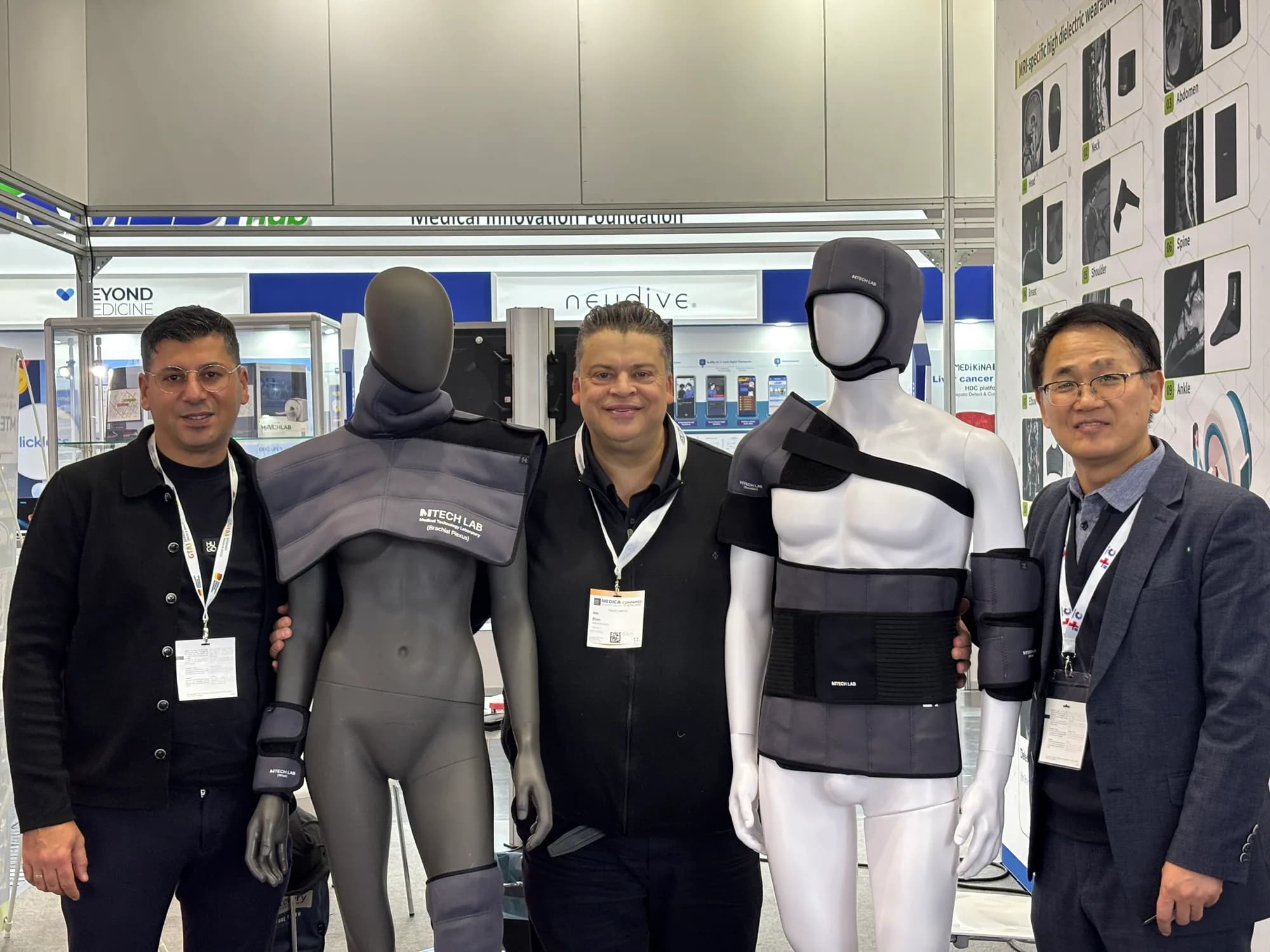 International visitors beside MRI pad mannequins with an MTechLab representative