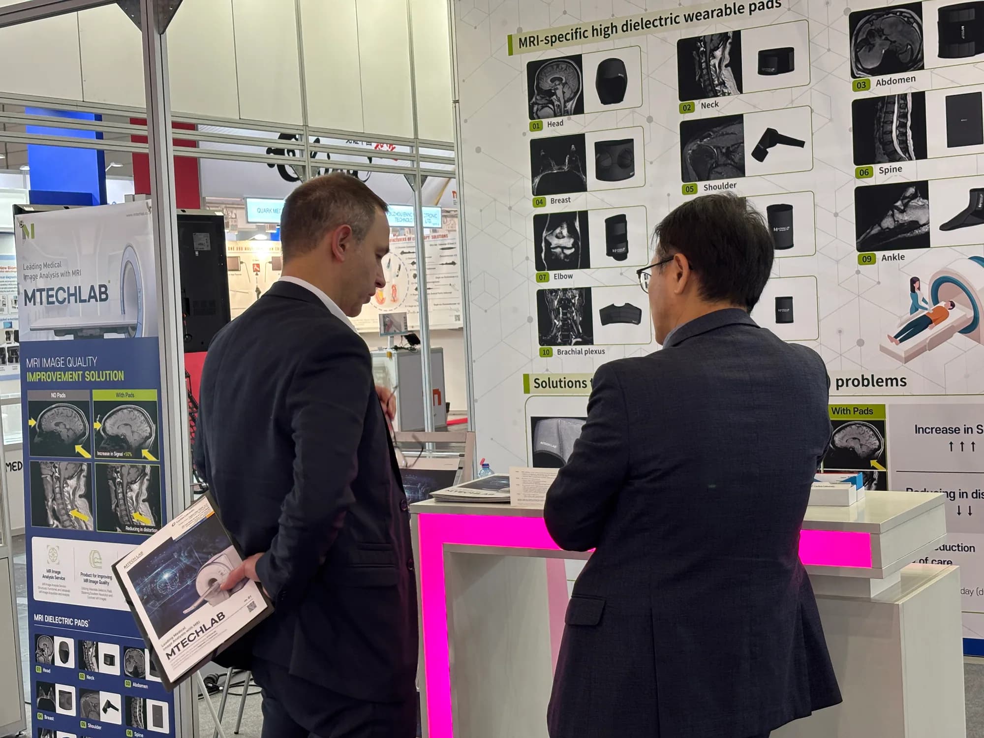 Technical discussion in front of the MTechLab MRI product display wall
