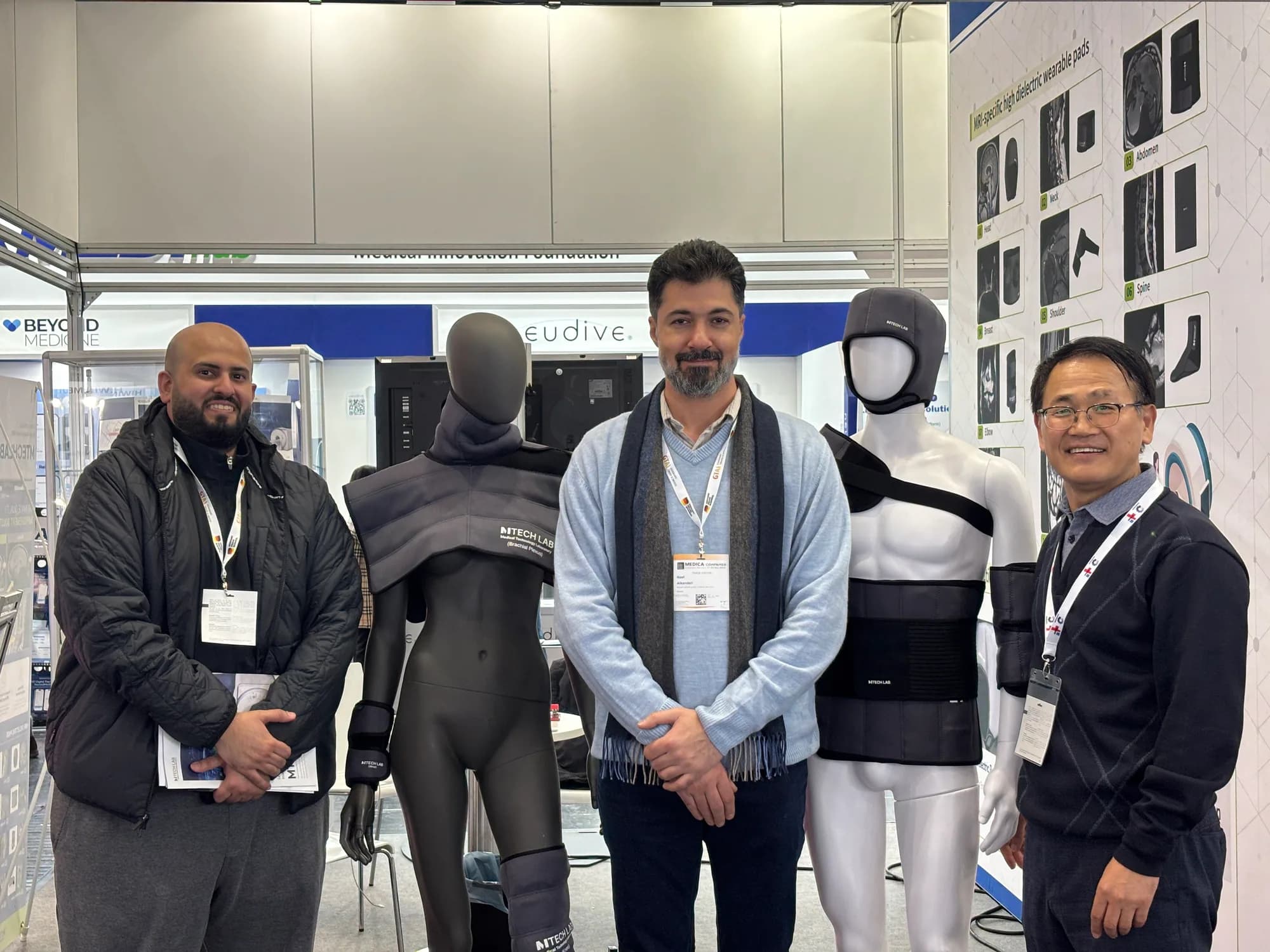 Visitors viewing wearable MRI dielectric pads with an MTechLab representative