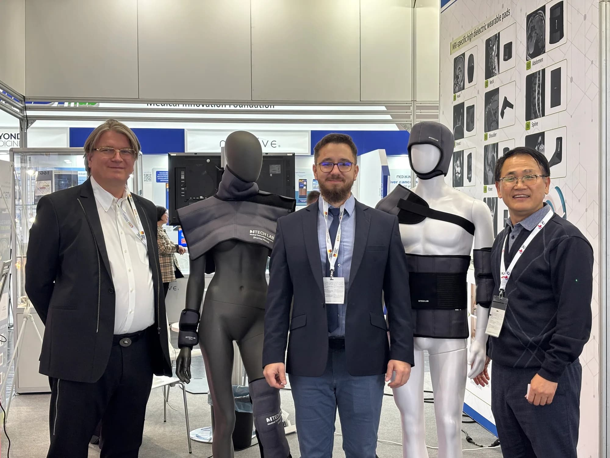 Visitors and MTechLab team beside mannequins wearing MRI dielectric pads