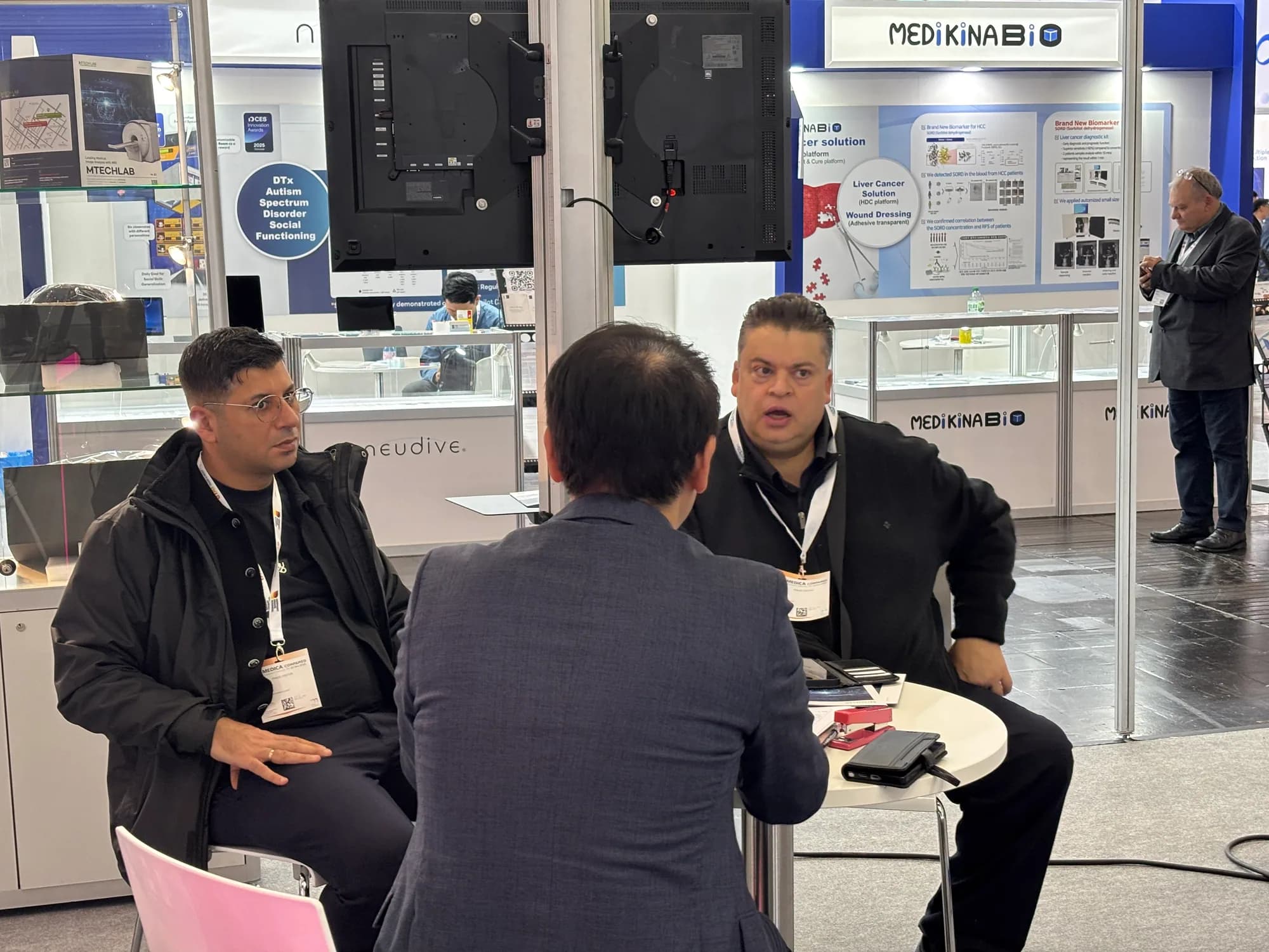 MTechLab representative in a seated discussion with a MEDICA 2025 visitor
