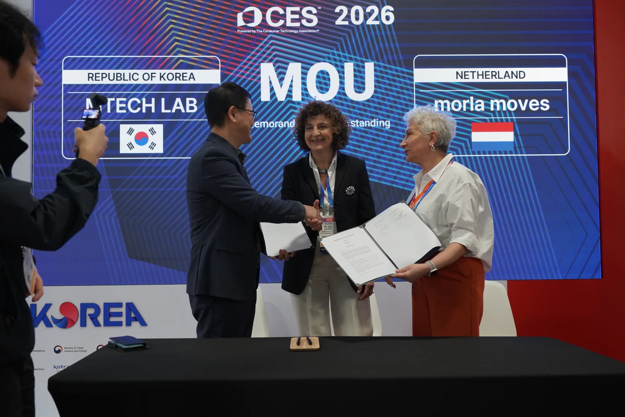 Representatives shaking hands after signing the partnership agreement