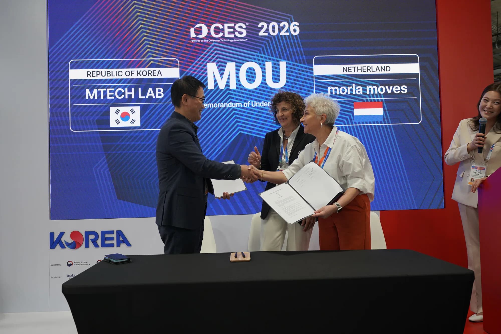 MTechLab and MORLA Moves representatives exchanging signed documents