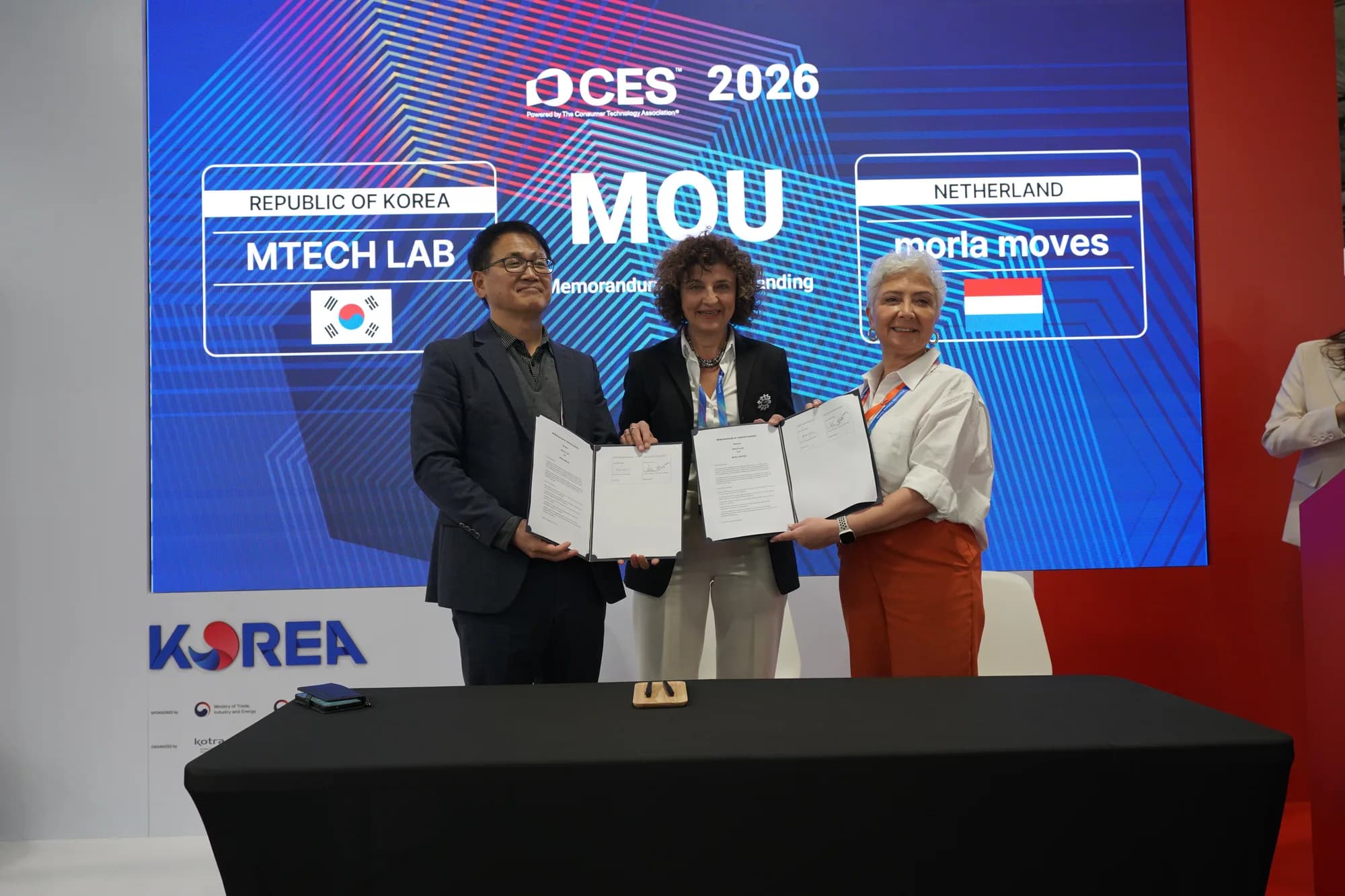 Representatives holding the completed partnership documents after the ceremony