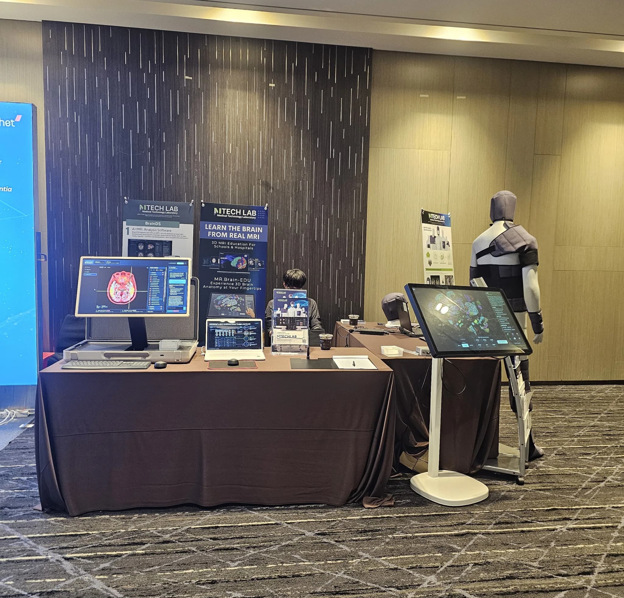 MTechLab’s ICMRI 2026 booth with MRI software displays, the MR.Brain-Edu touchscreen and a mannequin wearing MRI pads