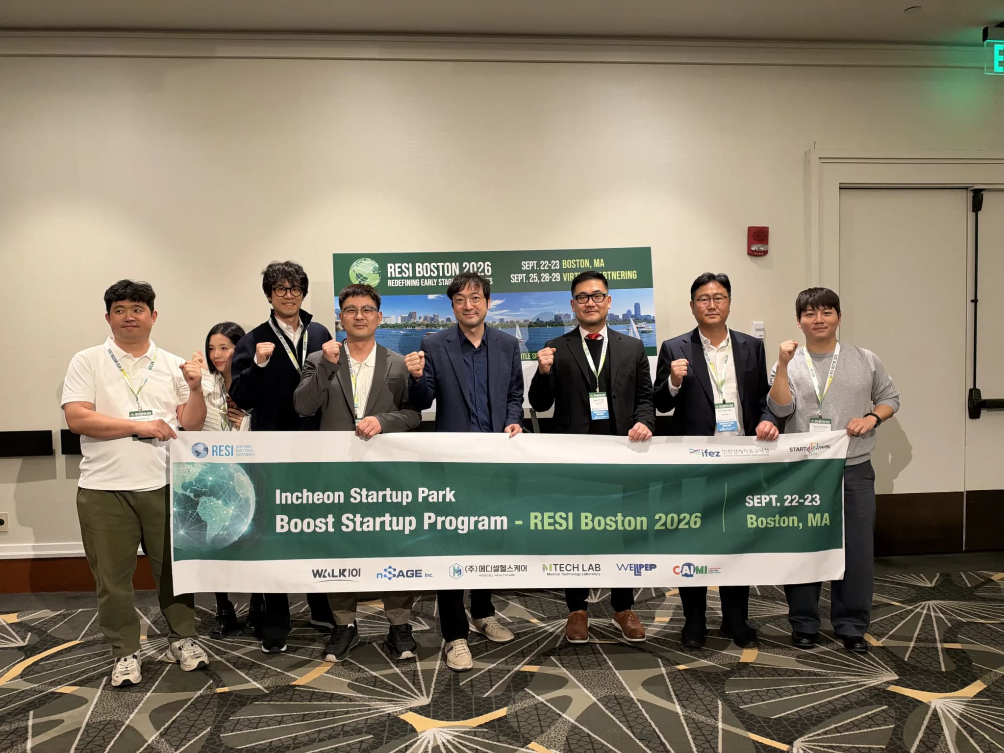 Incheon Startup Park’s RESI Boston 2026 delegation holding the Boost Startup Program banner, which carries the logos of the six participating companies, including MTechLab